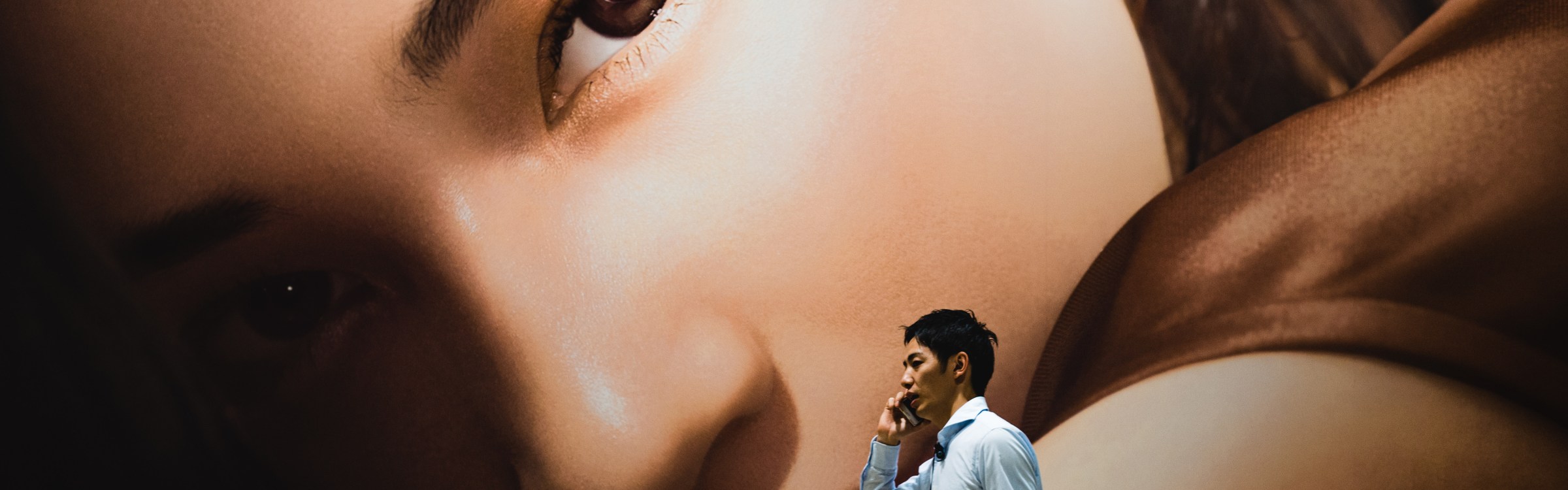 man walking by mural talking on mobile phone